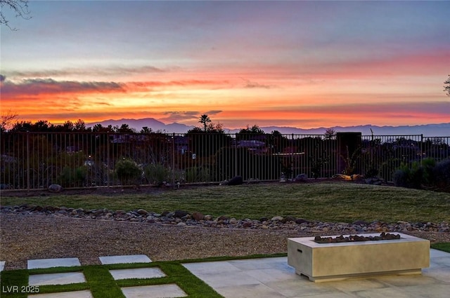 yard at dusk with a mountain view and a patio area