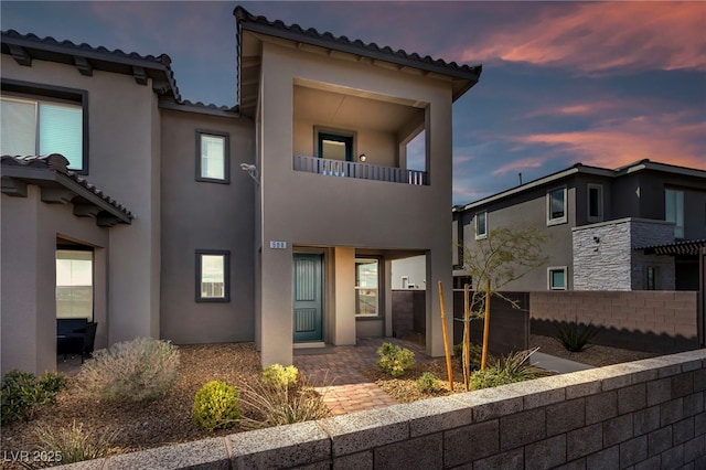 back of property featuring stucco siding and a tiled roof