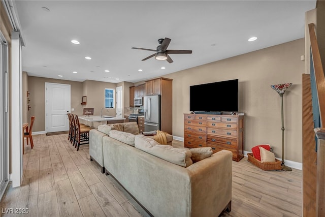 living area featuring recessed lighting, light wood-style floors, and baseboards