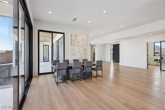 interior space with light wood-type flooring and a kitchen bar