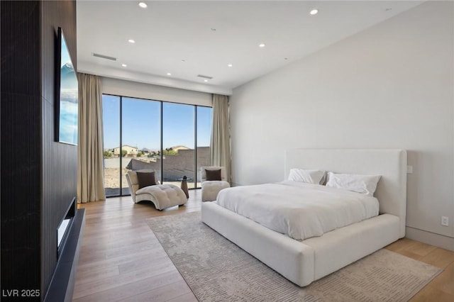 bedroom with light wood-type flooring and access to exterior