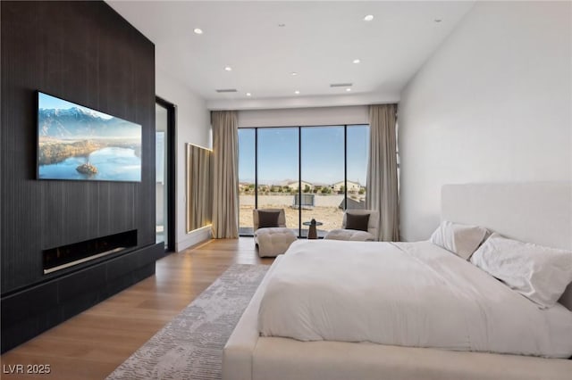 bedroom with access to outside and light hardwood / wood-style floors