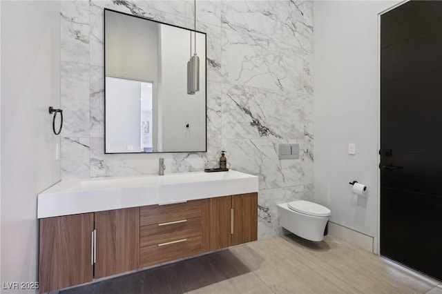 bathroom featuring toilet, tile walls, and vanity