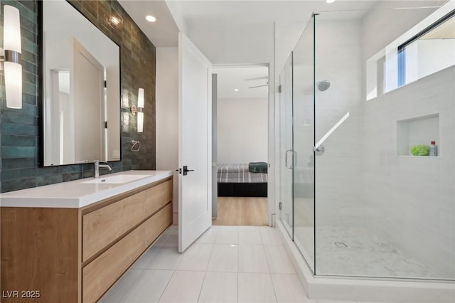 bathroom featuring tile patterned floors, backsplash, vanity, and an enclosed shower