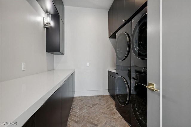 washroom with cabinets and stacked washer and dryer