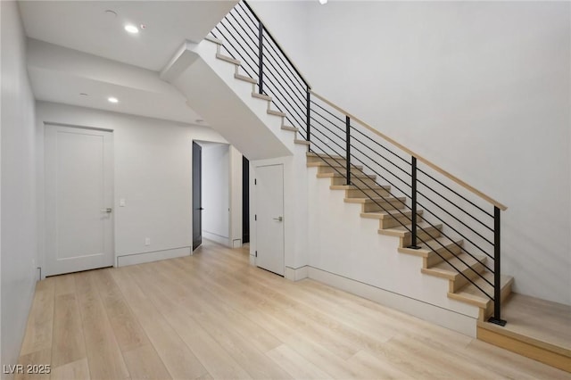 stairway featuring a high ceiling and hardwood / wood-style floors