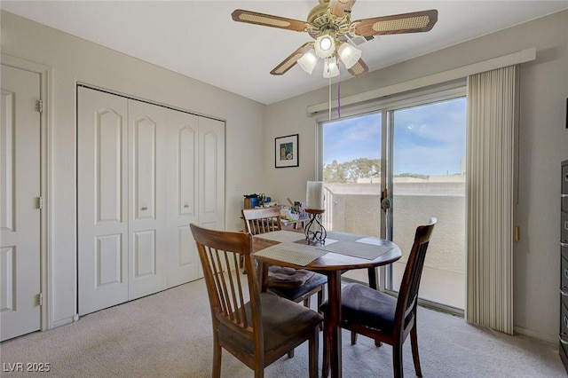 carpeted dining space with ceiling fan