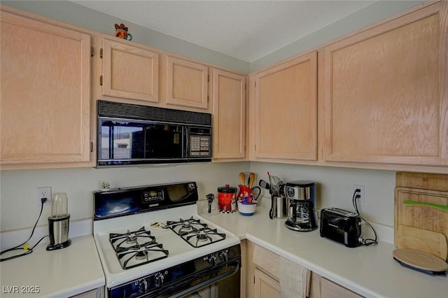 kitchen with range with gas stovetop and light brown cabinetry