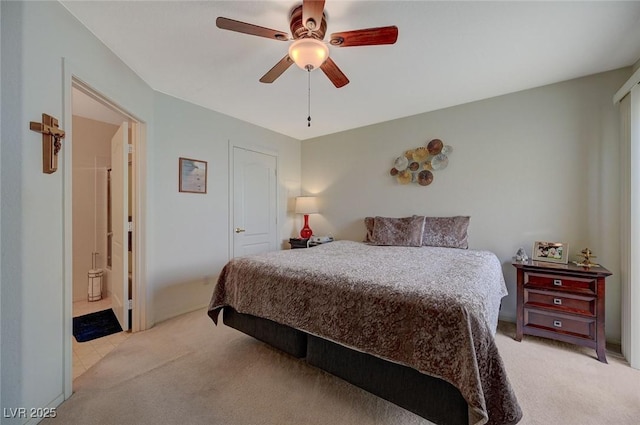 bedroom featuring ceiling fan, light carpet, and connected bathroom