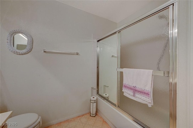 bathroom featuring bath / shower combo with glass door and toilet