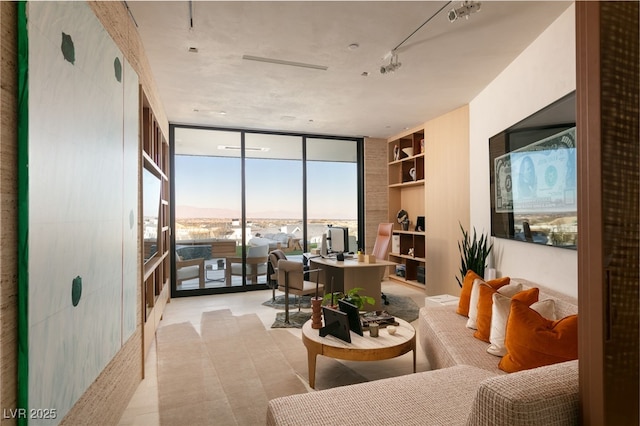 living room with a wall of windows, built in shelves, and rail lighting