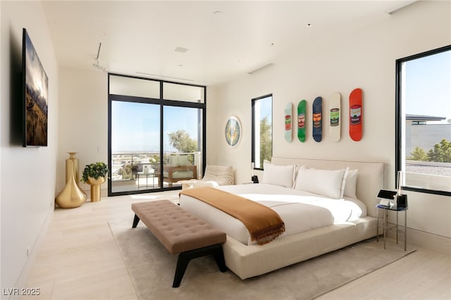 bedroom with expansive windows and access to outside