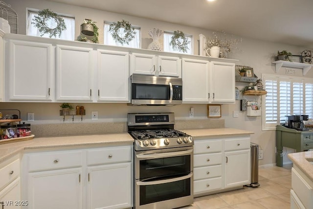 kitchen featuring appliances with stainless steel finishes, white cabinets, and light countertops