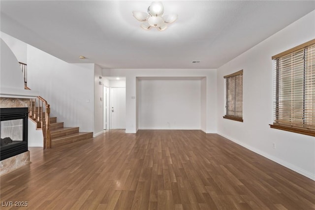 unfurnished living room featuring a tiled fireplace and hardwood / wood-style floors