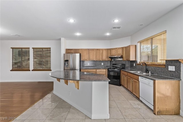 kitchen featuring black gas range oven, sink, stainless steel fridge with ice dispenser, white dishwasher, and tasteful backsplash