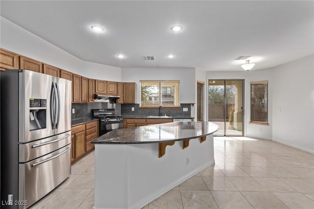 kitchen featuring a center island, sink, stainless steel refrigerator with ice dispenser, and black gas stove