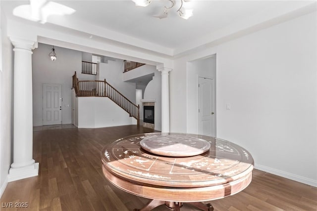 dining area with dark hardwood / wood-style flooring and decorative columns