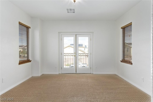 carpeted spare room with french doors