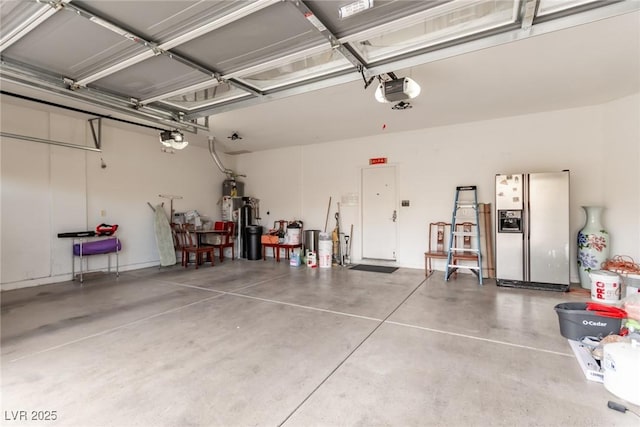 garage featuring white refrigerator with ice dispenser, a garage door opener, and gas water heater