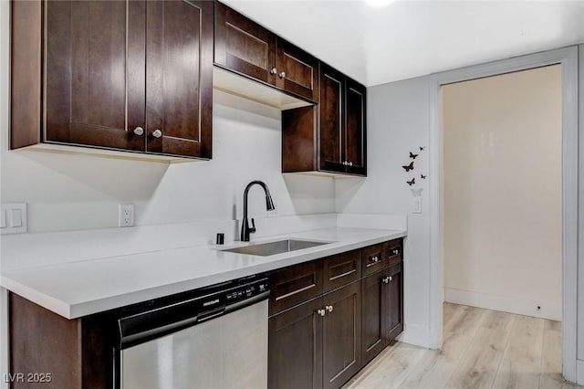 kitchen featuring light hardwood / wood-style floors, dark brown cabinets, dishwasher, and sink