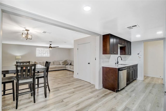 kitchen with light hardwood / wood-style flooring, sink, dark brown cabinets, and stainless steel dishwasher