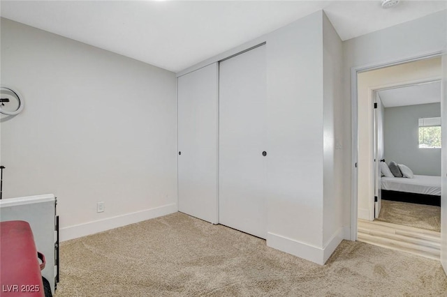 bedroom with light carpet and a closet