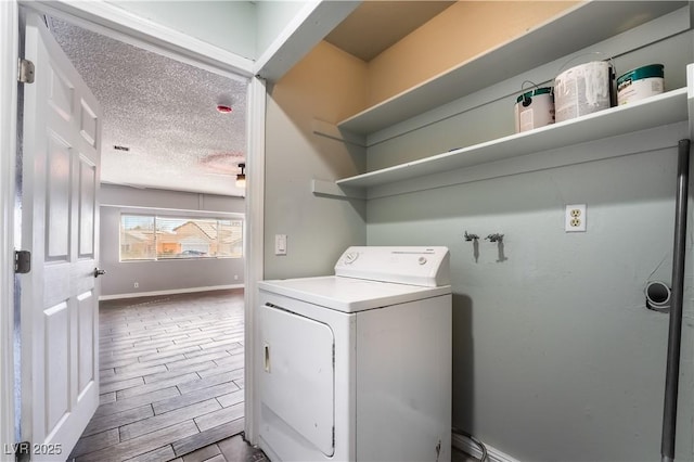 clothes washing area featuring washer / clothes dryer and a textured ceiling