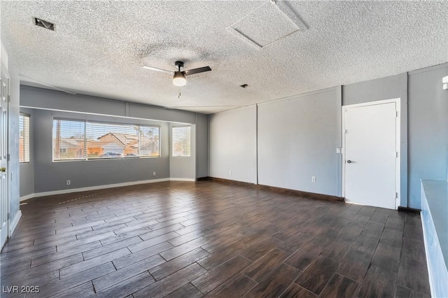 empty room featuring dark hardwood / wood-style flooring, ceiling fan, and a textured ceiling