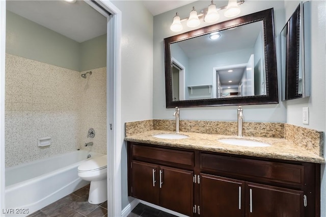 full bathroom with tile patterned floors, toilet, vanity, and tiled shower / bath combo