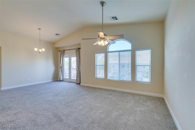 carpeted empty room featuring ceiling fan with notable chandelier and vaulted ceiling