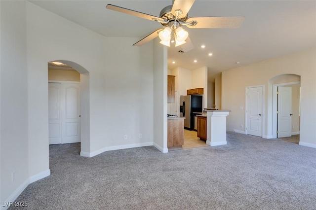 unfurnished living room featuring light colored carpet and ceiling fan