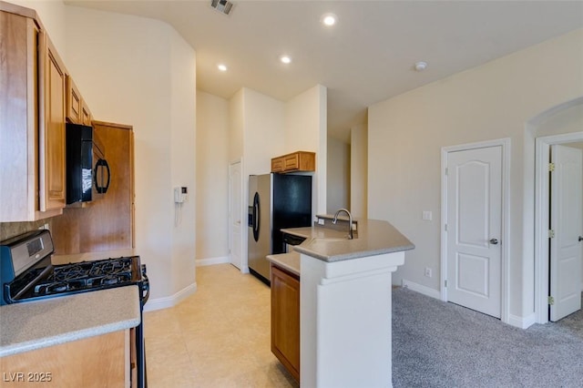 kitchen featuring sink, light colored carpet, and stainless steel appliances