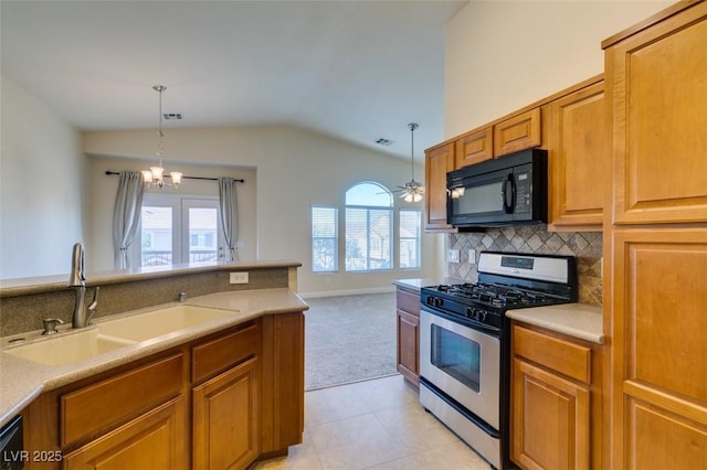 kitchen with sink, lofted ceiling, black appliances, and pendant lighting