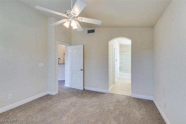 spare room featuring light carpet, lofted ceiling, and ceiling fan