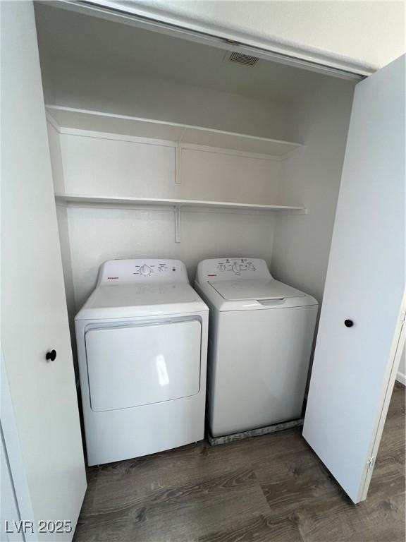 laundry room featuring dark wood-type flooring, laundry area, and independent washer and dryer