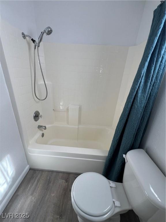 bathroom with shower / bathtub combination with curtain, toilet, and wood finished floors