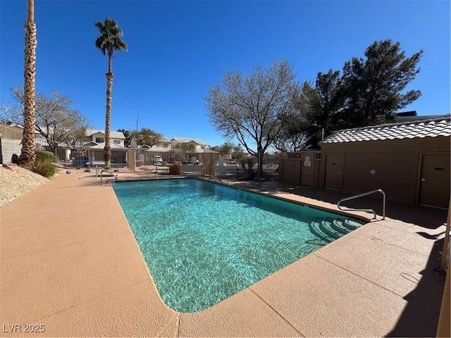 pool with a residential view, a patio, and fence