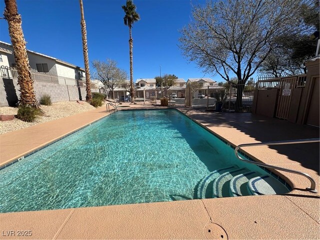 pool with a residential view and fence