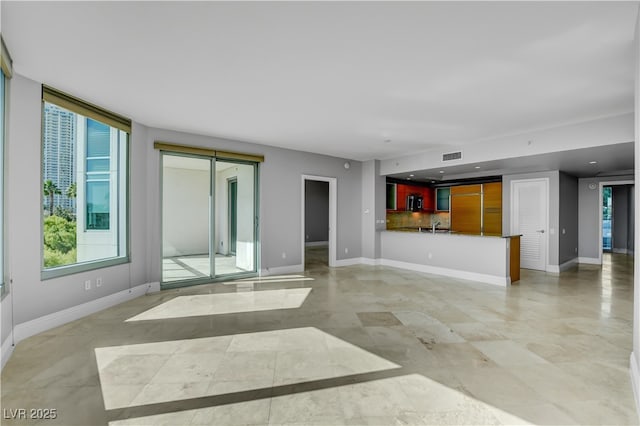 unfurnished living room with visible vents and baseboards