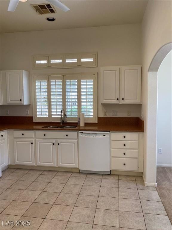 kitchen featuring visible vents, white cabinets, a sink, light tile patterned flooring, and dishwasher