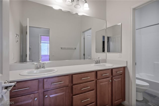 bathroom featuring double vanity, toilet, and a sink
