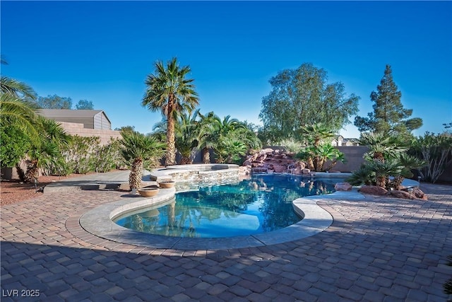 view of pool featuring a patio, a fenced in pool, a fenced backyard, and an in ground hot tub