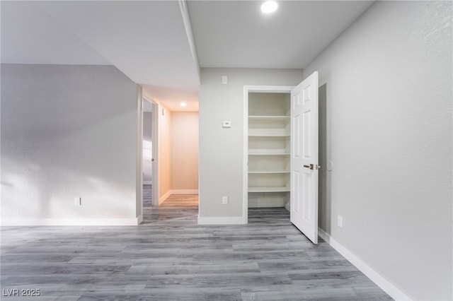 unfurnished bedroom with a spacious closet, light hardwood / wood-style floors, and a closet