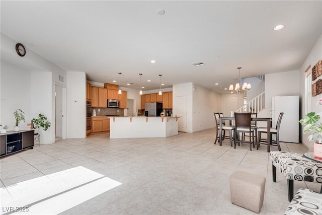 kitchen with a kitchen bar, visible vents, recessed lighting, appliances with stainless steel finishes, and a chandelier