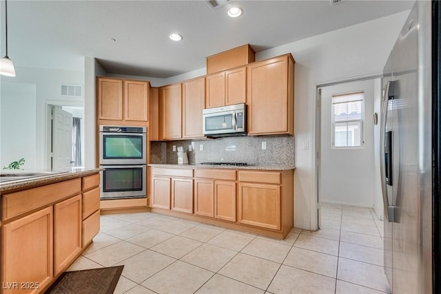 kitchen featuring visible vents, light brown cabinets, decorative backsplash, light tile patterned flooring, and stainless steel appliances