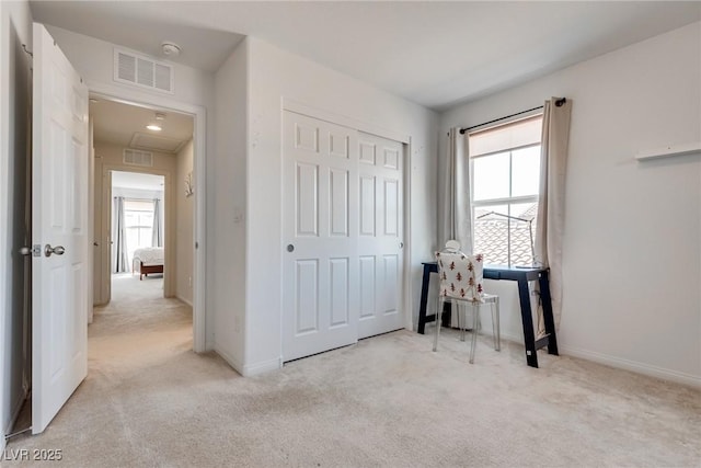 interior space with visible vents, light colored carpet, and multiple windows