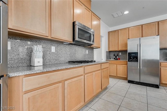 kitchen featuring light tile patterned floors, visible vents, light brown cabinets, and stainless steel appliances