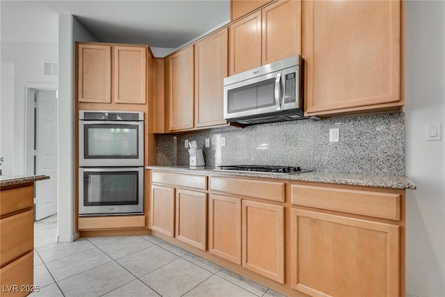 kitchen with tasteful backsplash, visible vents, light brown cabinets, and stainless steel appliances