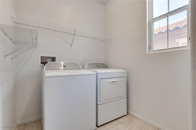 laundry room with laundry area, light tile patterned floors, baseboards, and washing machine and clothes dryer