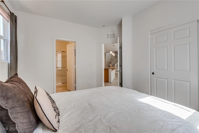 bedroom with visible vents and ensuite bathroom